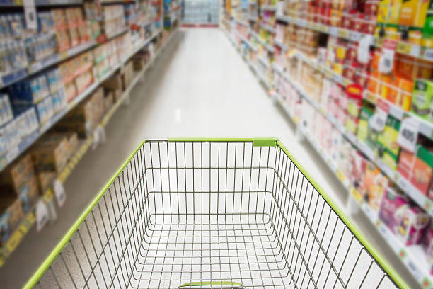 istock Supermarket interior, empty green shopping cart. 516006456