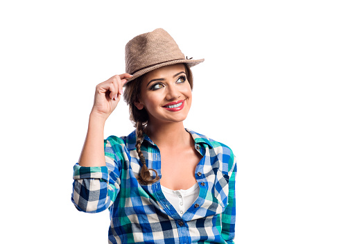 Woman with plait in blue and green checked shirt smiling. Studio shot on white background.