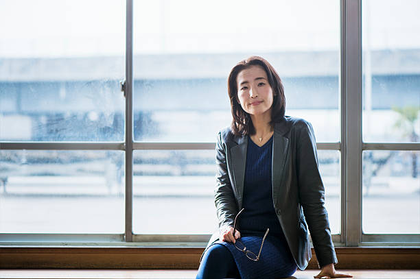 Senior adult businesswoman of the portrait Businesswoman sitting at the window of the bench in pride we trust stock pictures, royalty-free photos & images