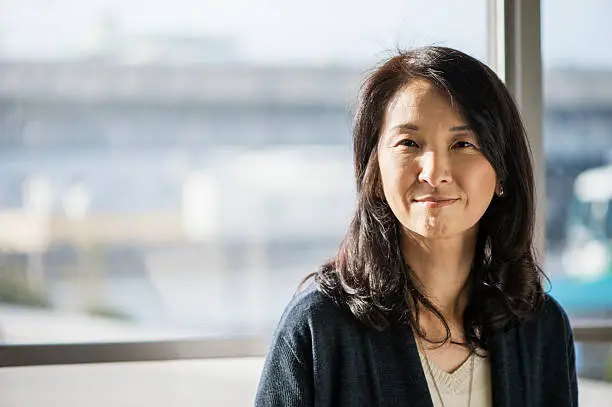 Photo of Businesswoman standing in the office of the window