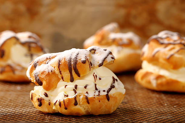 istock Cream puff cake with filling and chocolate icing 516011878