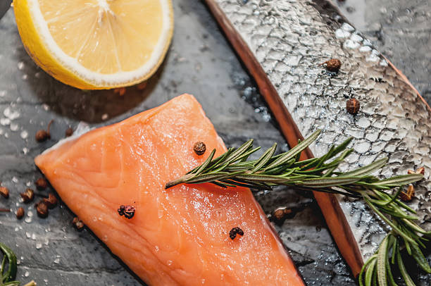 istock Raw Salmon and ingredientsfor cooking on a dark background 516012192