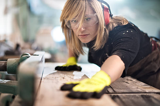 blondine frau schneiden ein plank - carpenter carpentry craft skill stock-fotos und bilder