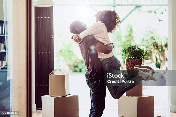 Happy Man Lifting Woman In New House Stock Photo - Download Image Now - Moving House, Home Ownership, Couple - Relationship