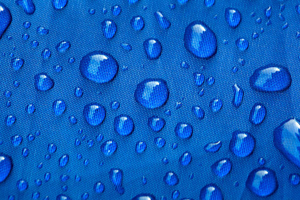 istock Closeup of rain drops on a blue umbrella 516014707