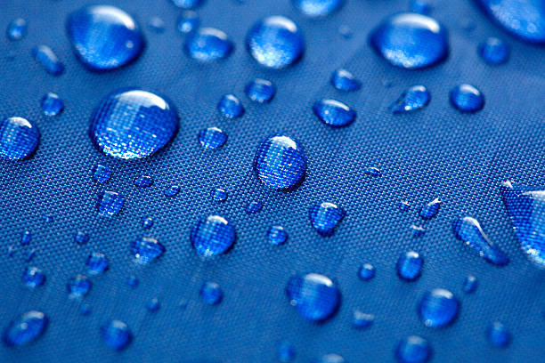 istock Closeup of rain drops on a blue umbrella 516015043