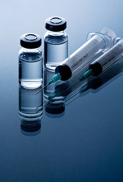 istock medical ampoules and syringe on blue background 516015665