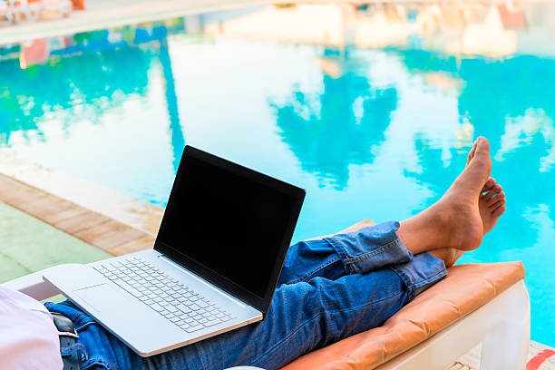 istock bare feet of a businessman on vacation pool 516016959