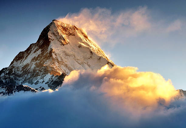 Sunrise over Snow capped mountain Machapuchare, Annapurna Himalaya Dramatic sun light sunrise over snow capped mountain Machapuchare Fish Tail mountain in Annapurna Himalaya, taken during trekking to Poon Hill Nepal. Machhapuchchhre or Machhapuchhre Lit. "Fish Tail" in English, is a mountain in the Annapurna Himal of north central Nepal. It is revered by the local population as particularly sacred to the god Shiva, and hence is off limits to climbing. annapurna conservation area photos stock pictures, royalty-free photos & images