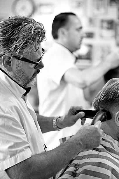 istock Barber shaving back of customers head 516017513