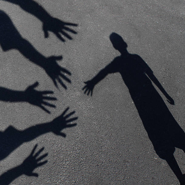 Community Support Community support and helping  children concept with shadows of a group of extended adult hands offering help or therapy to a child in need as an education symbol of social responsibility t for needy kids and teacher guidance to students who need extra care. social responsibility photos stock pictures, royalty-free photos & images