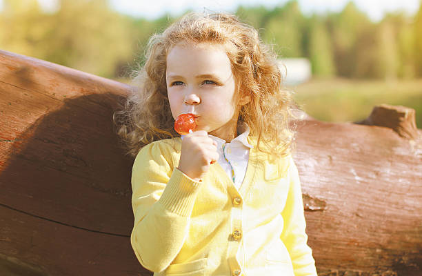 istock Little child with sweets having fun outdoors 516020975