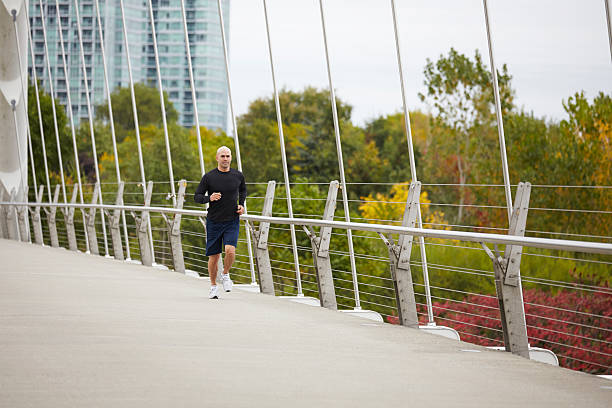 istock Man jogging on the bridge in autumn city 516021561