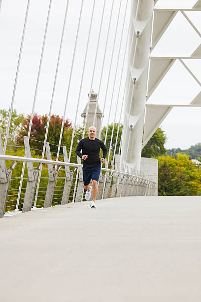 istock Man jogging on the bridge in autumn city 516021573