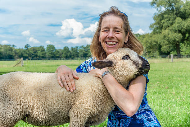istock Woman embracing and hugging young sheep 516021723
