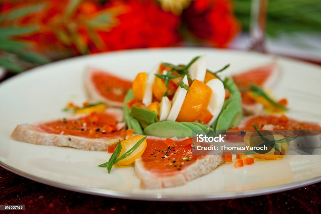 Tuna Carpaccio Tuna carpaccio with avocado, hearts of palm, and heirloom tomato salad. Carpaccio - Food Stock Photo