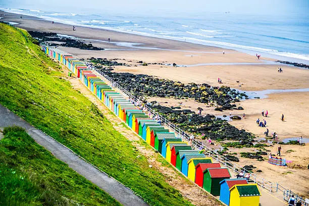 Picture of a lineup of colourful beach huts in Whitby, UK.