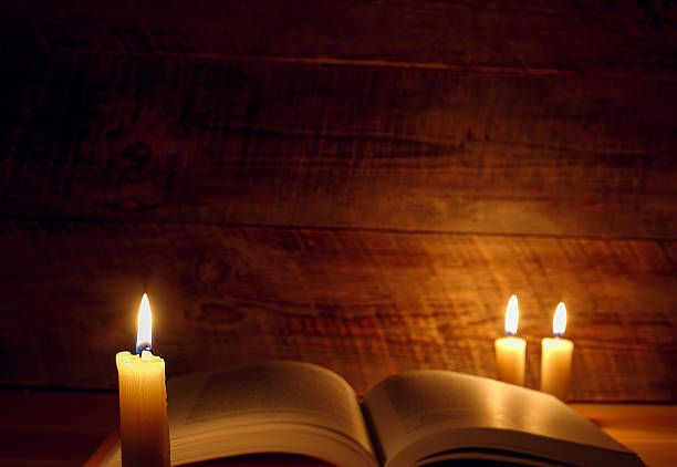 istock old book on a wooden table by candlelight 516037634