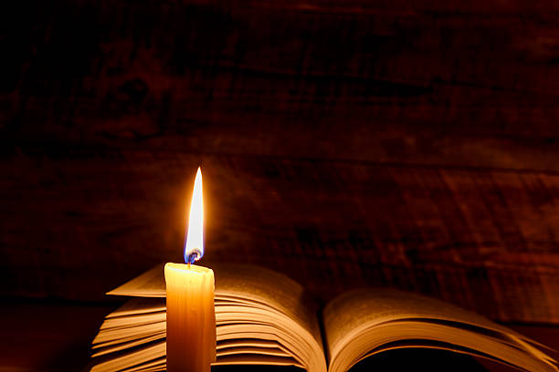 istock old book on a wooden table by candlelight 516037858