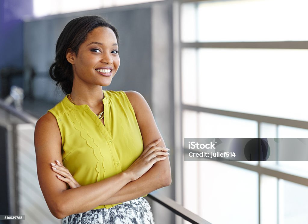 Portrait of a confident black businesswoman at work in her Friendly african american woman standing with arms crossed in a modern bright office Women Stock Photo