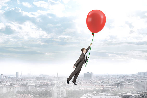 istock Businessman holding balloon and flying 516040652