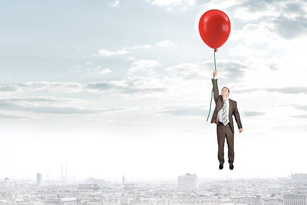 istock Businessman holding balloon and flying 516040730