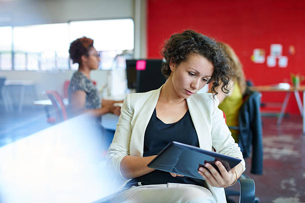 istock Confident female designer working on a digital tablet in red 516040834