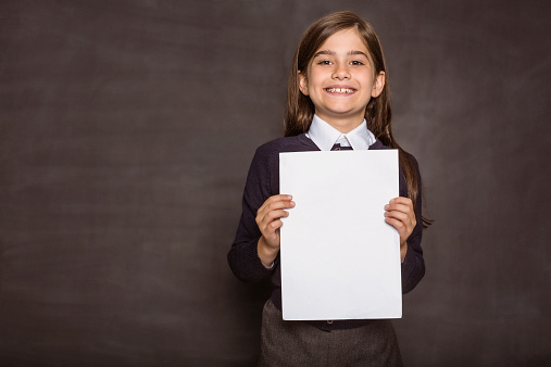 Cute pupil showing white page on black background