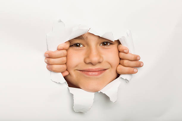 istock Cute little girl peeking through paper 516041897