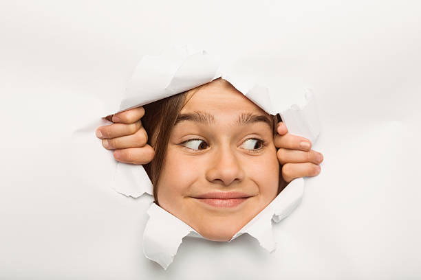 istock Cute little girl peeking through paper 516041905