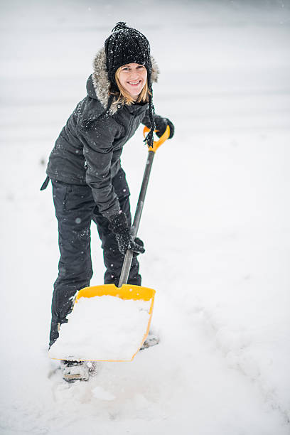 istock Shovelling snow off her driveway after a storm 516043433