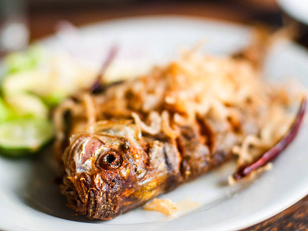 istock Fish fry, focus on the fish head. 516045040