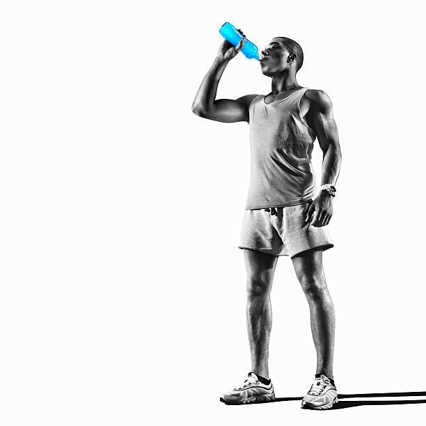 Sport. Young athlete drinking water of bottle after running Young muscular build man drinking water of bottle after running, attractive athlete resting after workout outdoors, fitness and healthy lifestyle concept. Isolated on white sport drink stock pictures, royalty-free photos & images