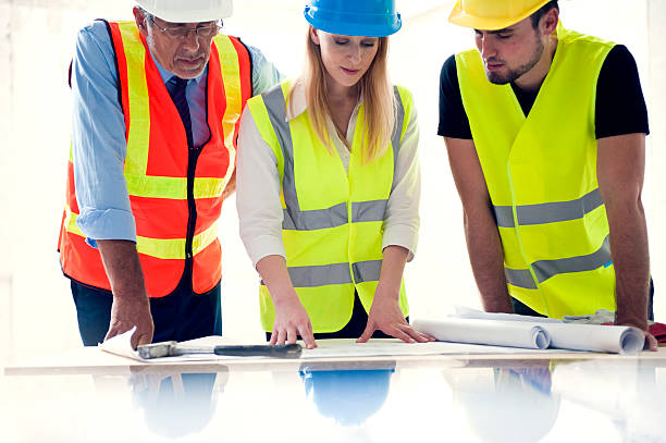 istock Architect and workers lookig at building plans 516047178