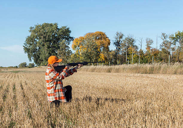 istock lady hunter crouched down with her rifle raised to shoulder 516060597