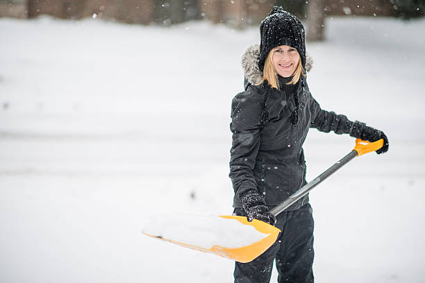 istock Shovelling snow off her driveway after a storm 516061429
