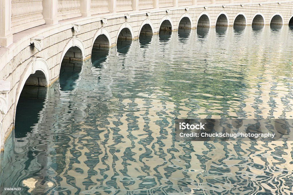 Bridge Arch Bellagio Fountain Pool Repeating tunnel arches beneath an elevated roadway bridge across a small lake. Arch - Architectural Feature Stock Photo