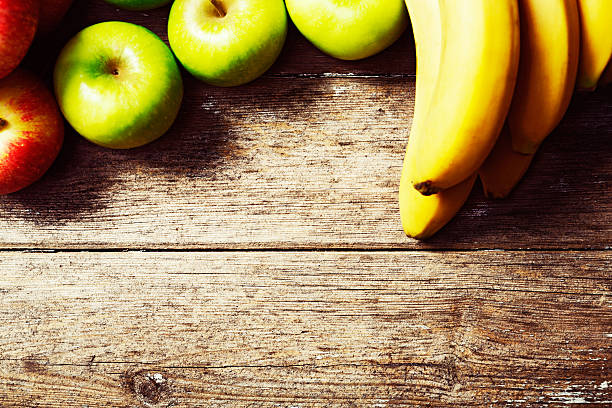 istock Crisp apples and ripe bananas on wood with copy space 516062985