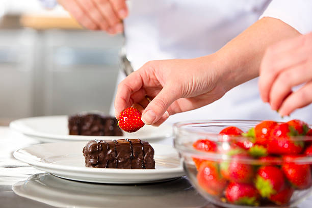 istock Chefs decorates dessert cake with chocolate sauce in kitchen 516064034