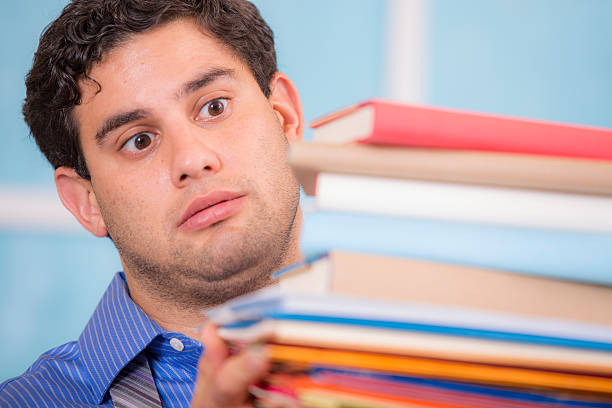istock Overwhelmed business man holding large stack of files, books, paperwork. 516064411