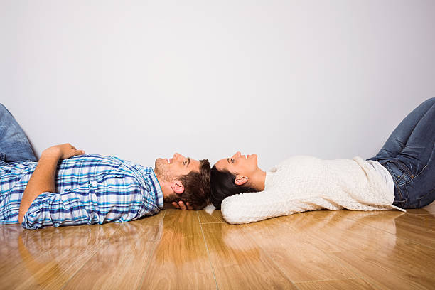 istock Young couple lying on floor smiling 516065475