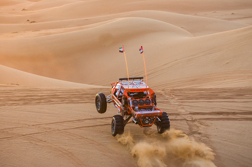 Dubai,UAE - November 29, 2013: dune buggy performs a show for tourist  on the  29th of november 2013 in Dubai, UAE.The Dubai desert trip in off-road car is major tourists attraction, Dubai,