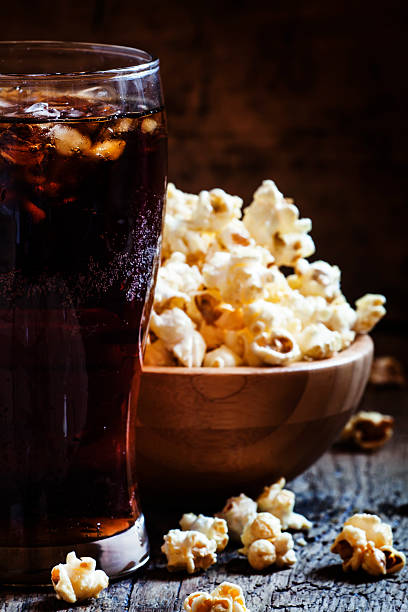 istock Cold cola in glass and sweet popcorn in bowl 516065964
