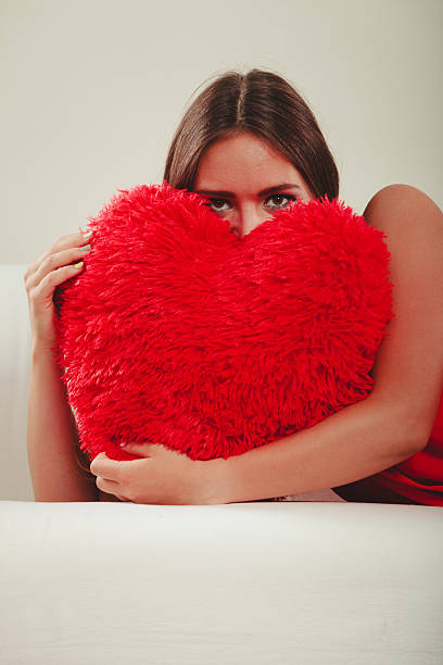 istock Woman hugging heart shape pillow. Valentines day. 516069152