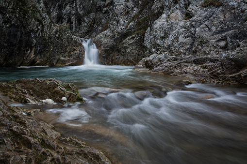 Myrafälle Waterfalls in Austria with wooden boardwalk and railing creating a vanishing point that creates leading lines blurred water due to long exposure photography