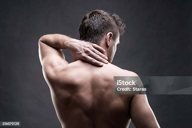 Pain In The Neck On Gray Background Stock Photo - Download Image Now - Rear View, Men, Back