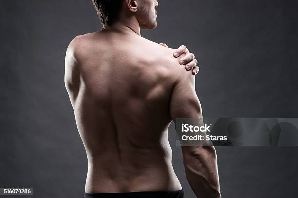 Dolor En El Hombro Sobre Fondo Gris Foto de stock y más banco de imágenes de Hombres - Hombres, Vista posterior, Espalda - Partes del cuerpo