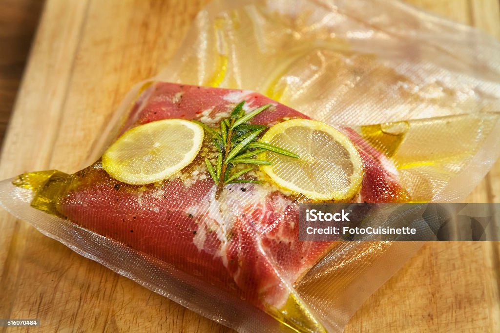 Spiced steak in vacuumed package. Beefsteak in olive oil with rosemary and lemon in vacuumed package. Sous-vide. Airtight Stock Photo