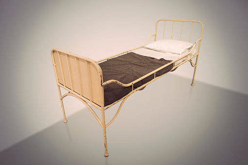 vintage metal hospital bed on neutral background