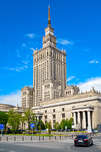 Photo of the Palace of Culture and Science, an old, landmark skyscraper in downtown Warsaw, Poland. It was built in 1955 and houses public institutions, cinemas, theaters, libraries, sports clubs, universities, scientific institutions and offices of the Polish Academy of Sciences. 